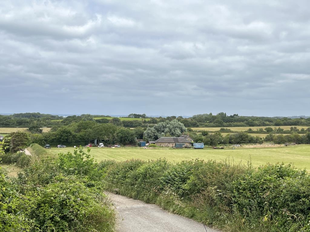 Lot: 36 - FREEHOLD RURAL BARN WITH CONSENT FOR CONVERSION ON A PLOT OF 1.27 ACRES - A view looking done onto the site from the top road